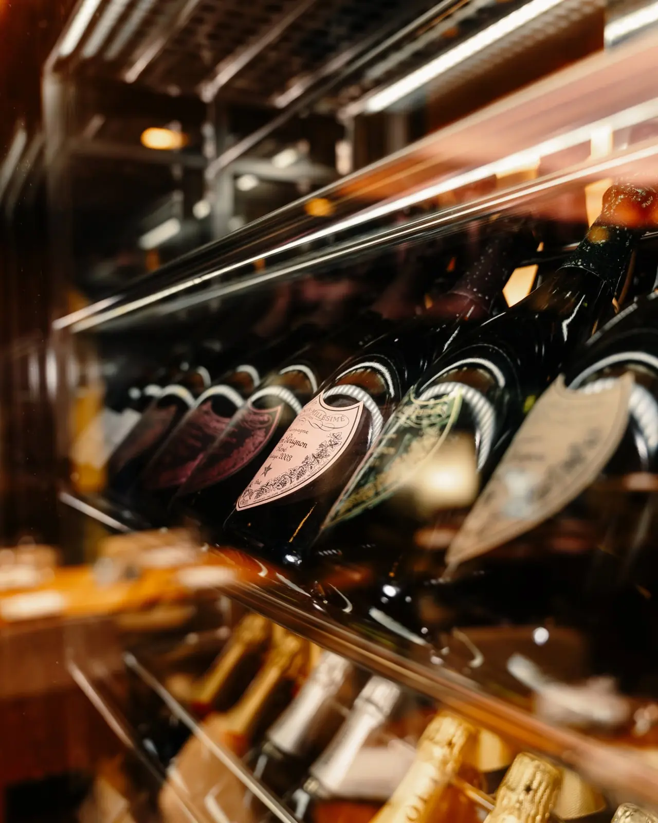 Vintage champagne bottles resting in NAMA's chilled wine cabinet