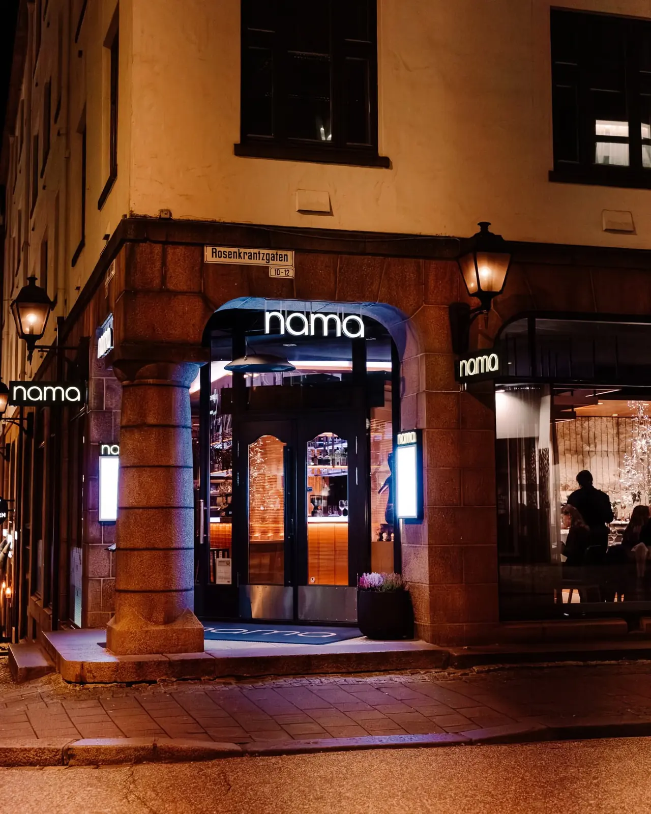 NAMA's illuminated corner entrance on Rosenkrantzgaten in Bergen at night