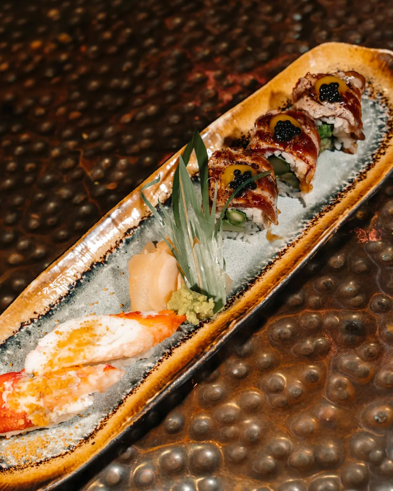 Seared nigiri and maki with caviar served on a long ceramic plate at NAMA