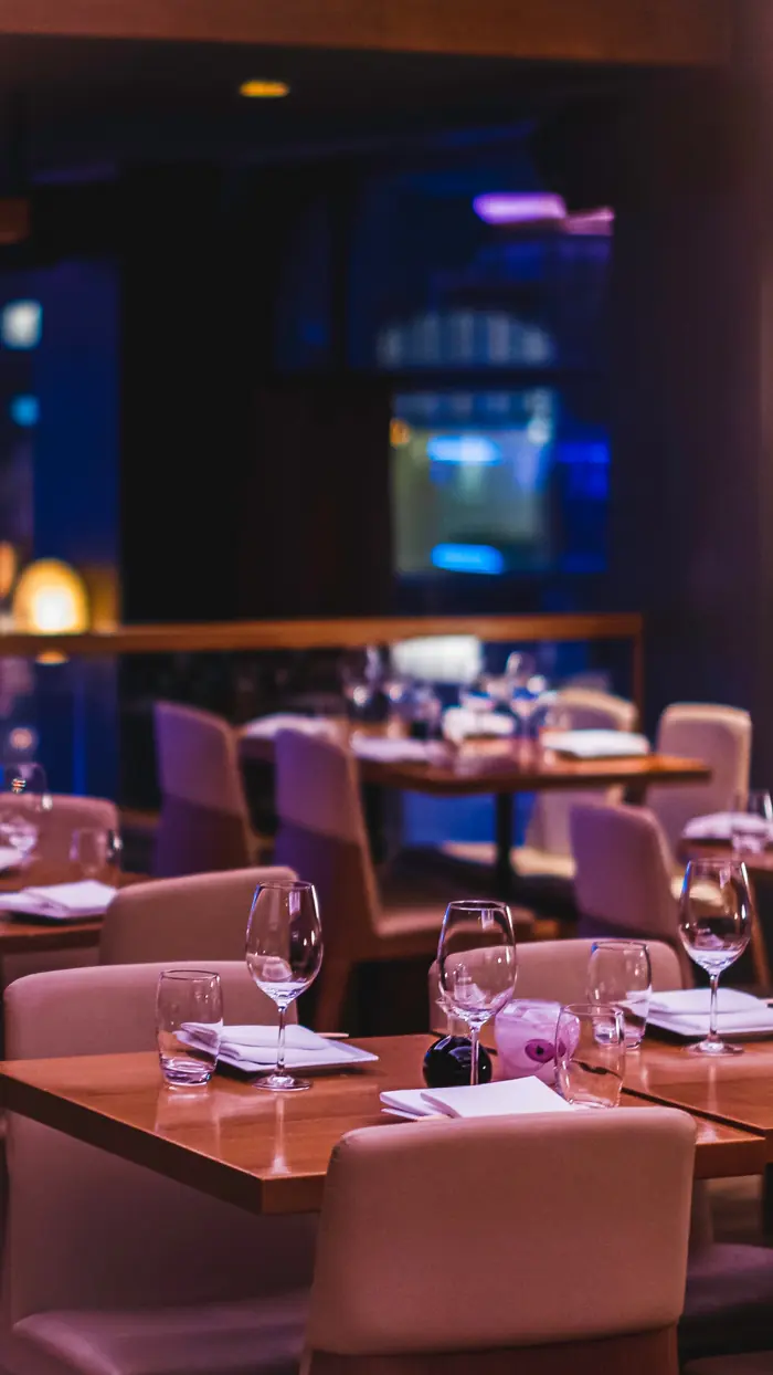 Dining room at NAMA in the evening with set tables and blue window light