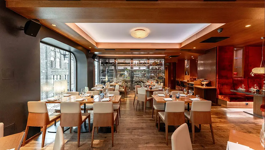 Dining room at NAMA with a glass wine cabinet and set tables