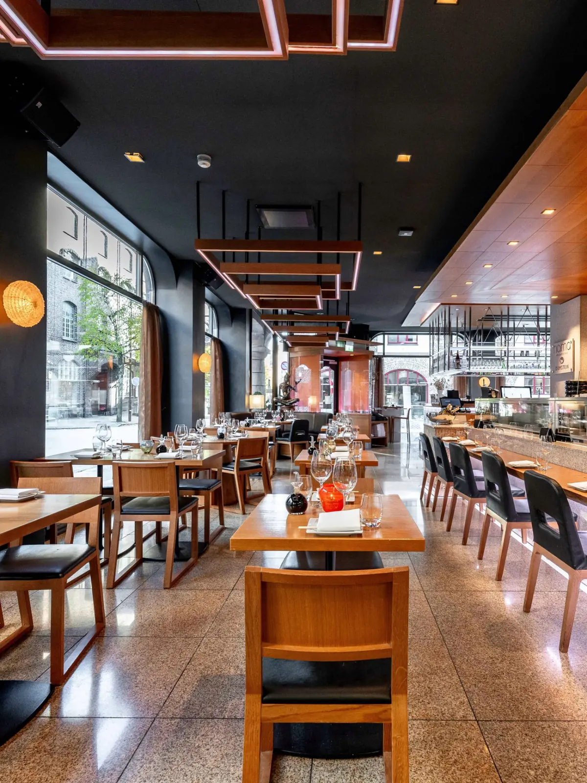 NAMA's main dining room with the sushi counter and tall arched windows